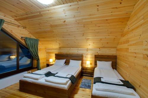 シェレゲシュにあるPanda houseのベッド2台 木製の壁の部屋