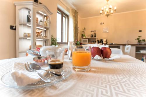 a table with two glasses of orange juice on it at Villa Malvasio Pool and Jacuzzi Room Sassari in Sassari