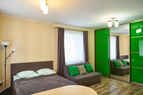 トムスクにある"GOOD NIGHT" on Nikitina 17aのベッド1台、ソファ、鏡が備わる客室です。