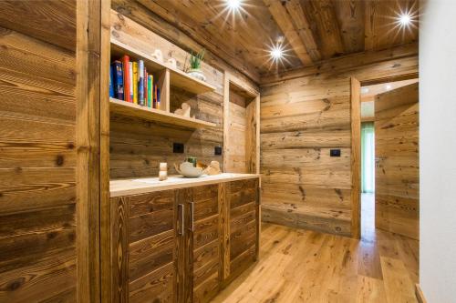 Cabaña de madera con baño con paredes y suelo de madera. en Lüch dl Cajer - Appartement Col, en San Martino in Badia