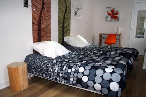 sypialnia z łóżkiem z czarno-białą kołdrą w obiekcie Hôtel Les Castets d'Ayré w mieście Barèges