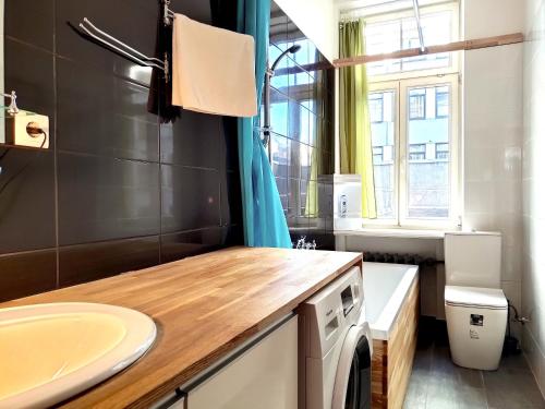 a bathroom with a sink and a washing machine at Brivibas Center Apartments in Riga