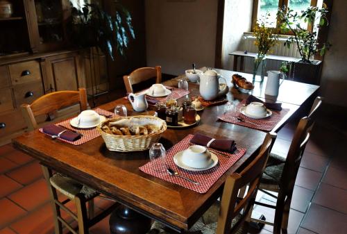 - une table à manger avec un ensemble de tables dans l'établissement La Ferme de Leix, à Clergoux