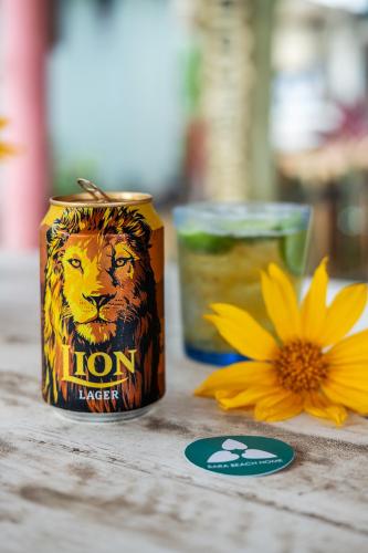 a can of lion energy drink next to a yellow flower at Bara Beach Home in Galle