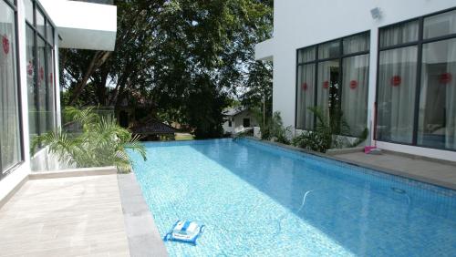 a swimming pool in front of a house at The Dahlias at Afamosa Melaka in Kampong Batang Melekek