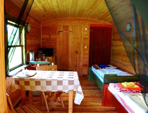 una habitación con mesa y 2 camas en una cabaña en Dolina 4 Stawów, en Krzywcza