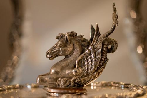 a statue of a horse with wings on a plate at Vittoria - house of charme in Messina