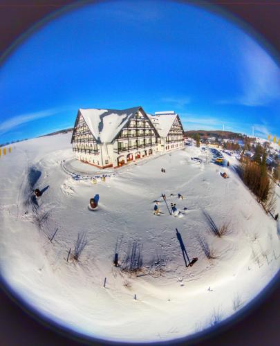 a large building in the snow with people in it at Alpina Lodge Hotel Oberwiesenthal in Kurort Oberwiesenthal