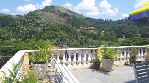 a balcony with potted plants and a view of a mountain at Morada Recanto das Flores in Miguel Pereira
