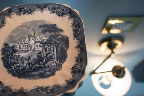 a blue and white plate next to a lamp at Vittoria - house of charme in Messina