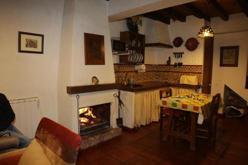 a living room with a fireplace and a table at Casa La Tinaja in Grazalema