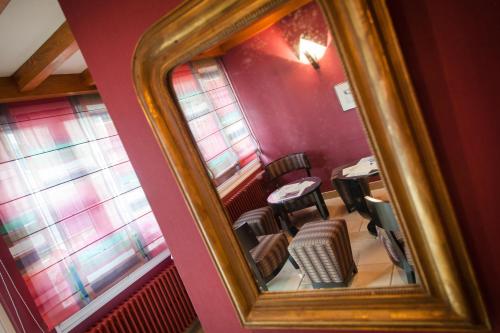 een spiegel in een kamer met een tafel en stoelen bij le bon accueil in Malbuisson