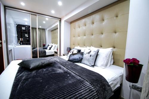 a bedroom with a large bed with a large headboard at Langery Residence Central Apartments in Odesa