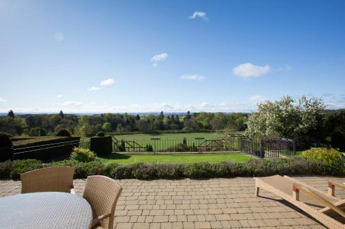 a patio with a table and chairs and a playground at Bowden House B&B in Melrose