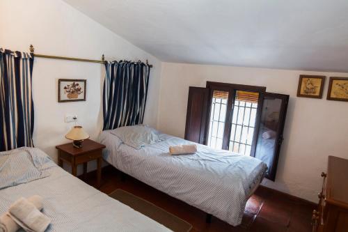 a bedroom with two beds and a window at Casa La Tinaja in Grazalema