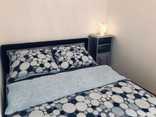 łóżko z czarno-białymi poduszkami i stolikiem nocnym w obiekcie Apartament Silesia Park w mieście Katowice