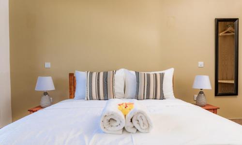 a bedroom with a white bed with two towels at Villa Lima in Mahe