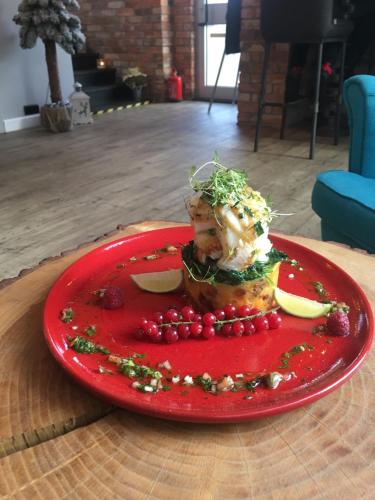 a red plate with food on a table at Stary Zajazd in Zielona Góra