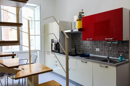 a small kitchen with red cabinets and a table at Fausto's House 2 in Syracuse