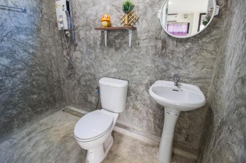 a bathroom with a toilet and a sink at Phor Kub Mae Homestay in Damnoen Saduak