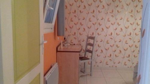 a bathroom with a sink and a chair at gîte vacances in Moncontour