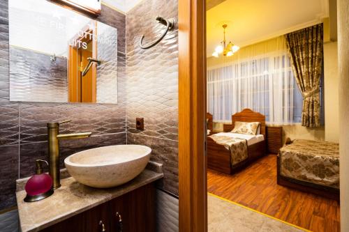 a bathroom with a sink and a bedroom at The First Ottoman Suites in Istanbul