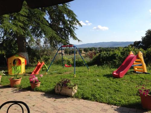 einen Garten mit einem Spielplatz mit Rutschen und einem Spielset in der Unterkunft Assisi Garden in Assisi