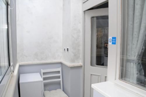 a small bathroom with a white door and a window at My Home, with free secure parking in Stara Zagora