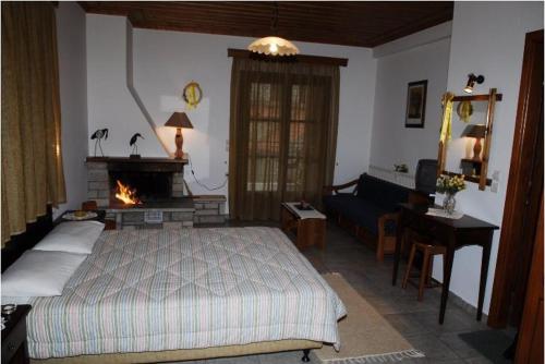 a bedroom with a bed and a living room with a fireplace at Petrino in Méga Khoríon