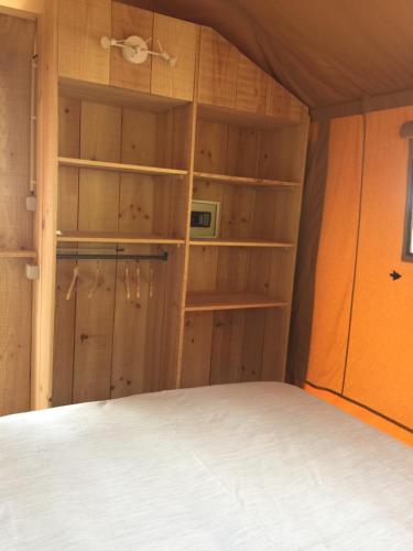 a bedroom with a bed and wooden walls and shelves at Quinta O Ninho in Monchique