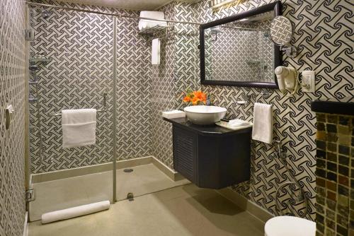 a bathroom with a sink and a shower at Taurus Sarovar Portico in New Delhi