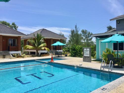 a swimming pool in front of a house at Casa Tanjung Jara in Dungun