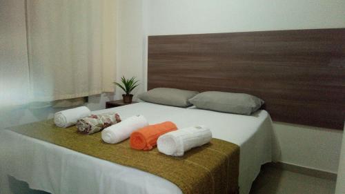 uma cama com quatro almofadas em cima em VG Fun Residence em Fortaleza