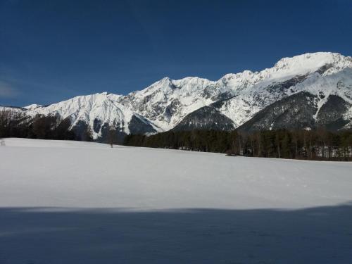 a snow covered mountain range with a field of snow at Pension Sonnenhof in Mieming