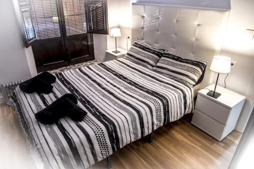 a bedroom with a large bed with two lamps at Plaza del Campo del Príncipe in Granada