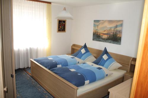 1 dormitorio con 2 camas y almohadas azules y blancas en Ferienwohnung Selbitschka, en Kirchberg