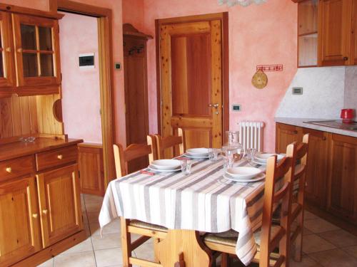 uma cozinha com uma mesa com pratos e copos em Residence Fior di Roccia em Campodolcino