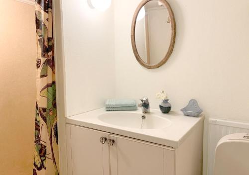 W łazience znajduje się umywalka i lustro. w obiekcie 18th century farm cottage w mieście Valdemarsvik