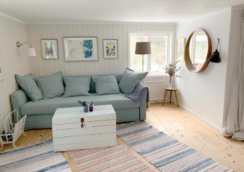 - un salon avec un canapé bleu et un miroir dans l'établissement 18th century farm cottage, à Valdemarsvik