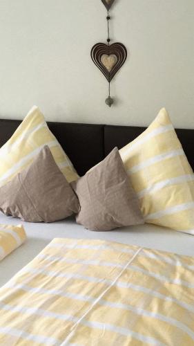 a bed with two pillows and a heart on the wall at Appartement Alpenhof Wildschönau in Niederau