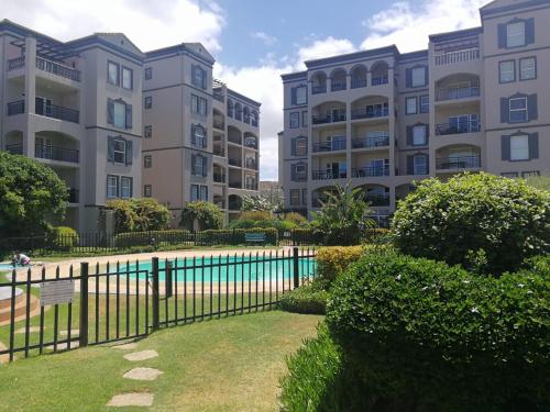 a group of apartment buildings with a pool in front at 11 Portobelo in Mossel Bay