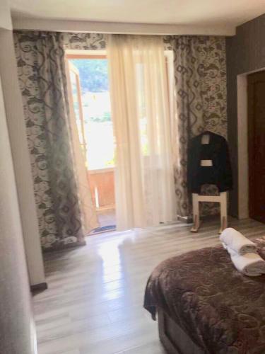 a bedroom with a bed and a large window at Apartment Jorjo Mestia in Mestia
