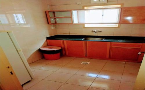 a small kitchen with a sink and a red trash can at برج سما للشقق المفروشة in Jeddah