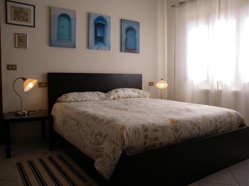 1 dormitorio con 1 cama, 2 lámparas y ventana en Il giardino di Otto, en Cascina