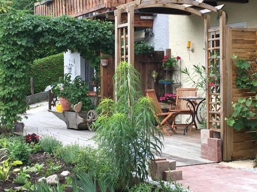 a garden with a wooden pergola and a table and chairs at Ferienhaus Langer in Bad Endorf