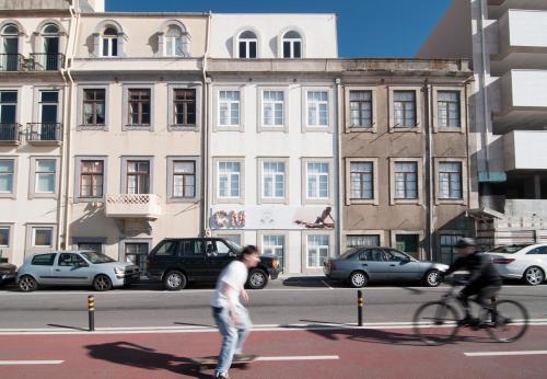 a man riding a skateboard down a city street at Flattered to be in Porto in Porto