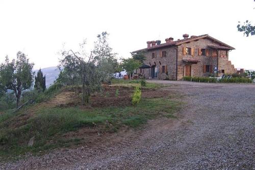 een oud huis op een heuvel met een onverharde weg bij Agriturismo Prato Barone in Rufina