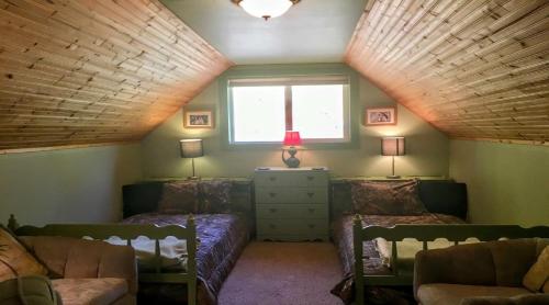 a attic room with two beds and a window at Packwood Ski & Vacation Getaway in Packwood