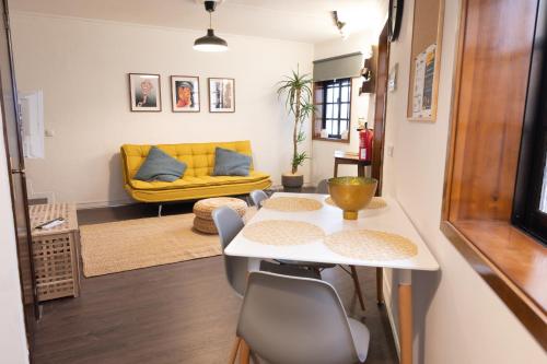 a living room with a table and a yellow couch at Invicta Flats 2 - Oporto in Porto