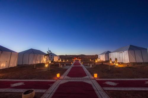 a row of domes in a field at night at Sahara Majestic Luxury Camp in Merzouga